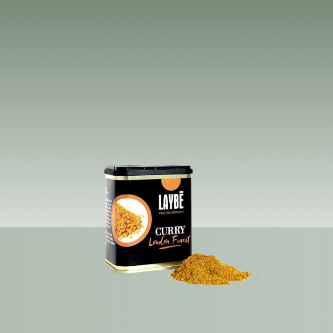 Lata metálica de curry Laybé London Finest con especia molida amarilla mostrada delante del envase.