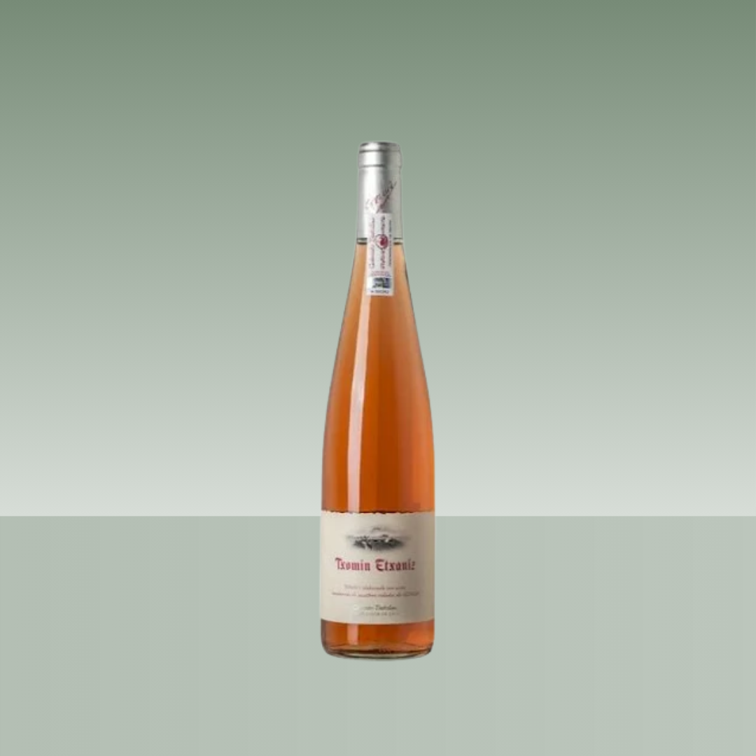 Botella de vino rosado Txomin Etxaniz, botella estilizada de vidrio transparente con cápsula plateada y etiqueta beige.