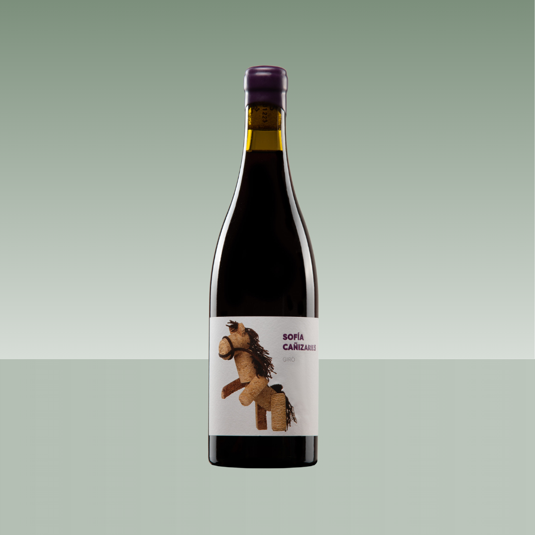 Botella de vino tinto Sofía Cañizares Giró con cápsula morada y etiqueta con ilustración de un caballito hecho de corcho, sobre fondo verde degradado.