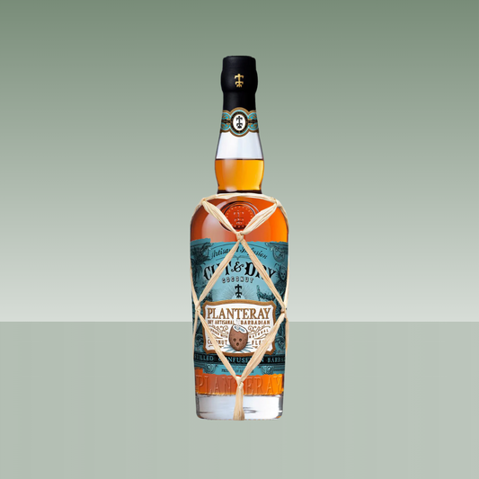 Botella de ron Planteray Cut & Dry Coconut de Barbados, con etiqueta azul y beige, vidrio transparente con ron ámbar y cuerda decorativa anudada alrededor del cuello.