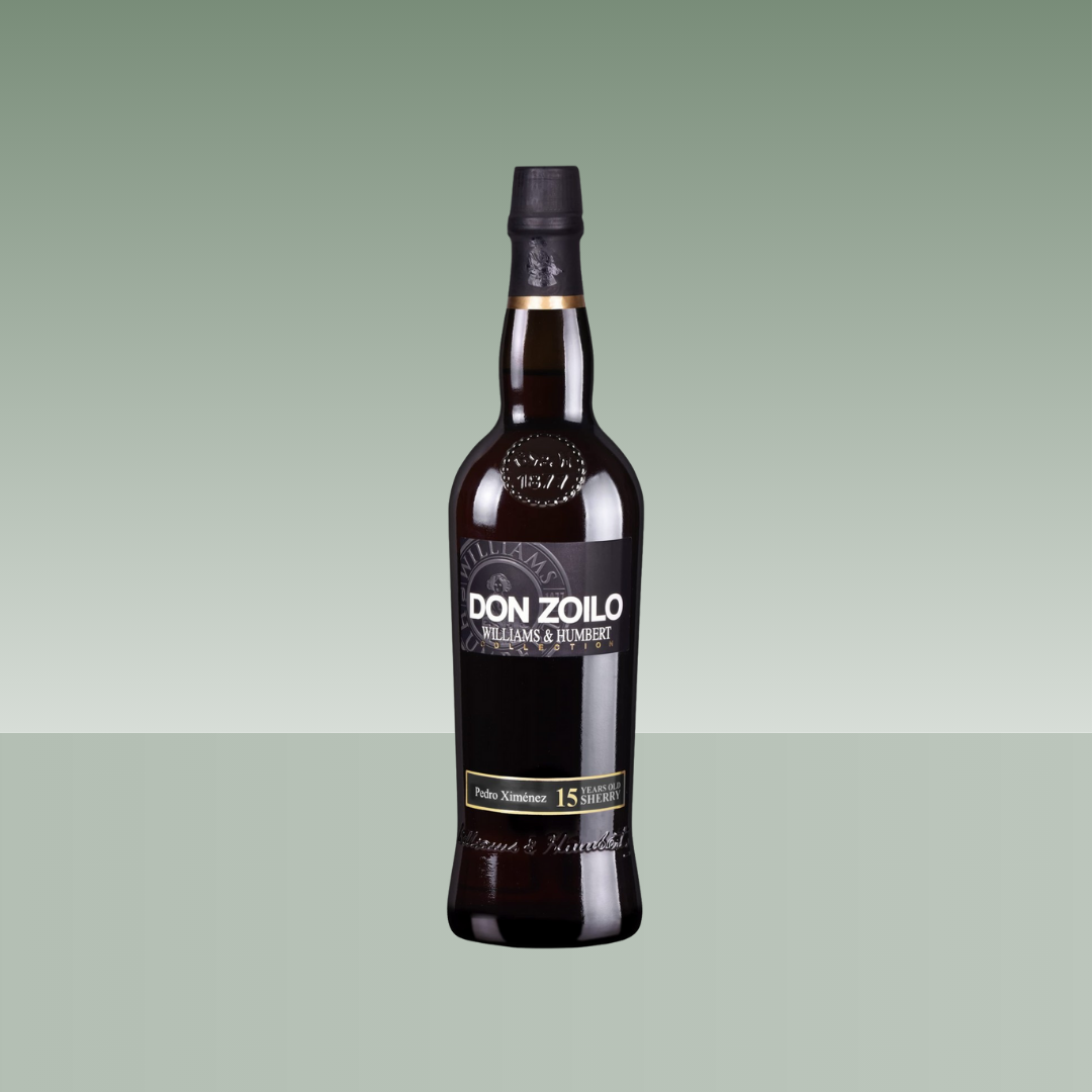 Botella de vino generoso Don Zoilo Pedro Ximénez 15 años de Williams & Humbert, con botella oscura, cápsula negra_toggle y etiqueta elegante en tonos negros y dorados, presentada sobre fondo neutro verde suave.