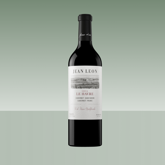 Botella de vino tinto Jean Leon Viña Le Havre 2021, Cabernet Sauvignon y Cabernet Franc, con botella oscura y etiqueta elegante en tonos blancos y grises, presentada sobre fondo neutro verde suave.