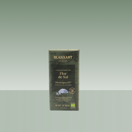 Tableta de chocolate negro Blanxart Origins Flor de Sal Nicaragua 85%, con envoltorio verde oscuro de diseño elegante, presentada sobre fondo neutro verde suave.