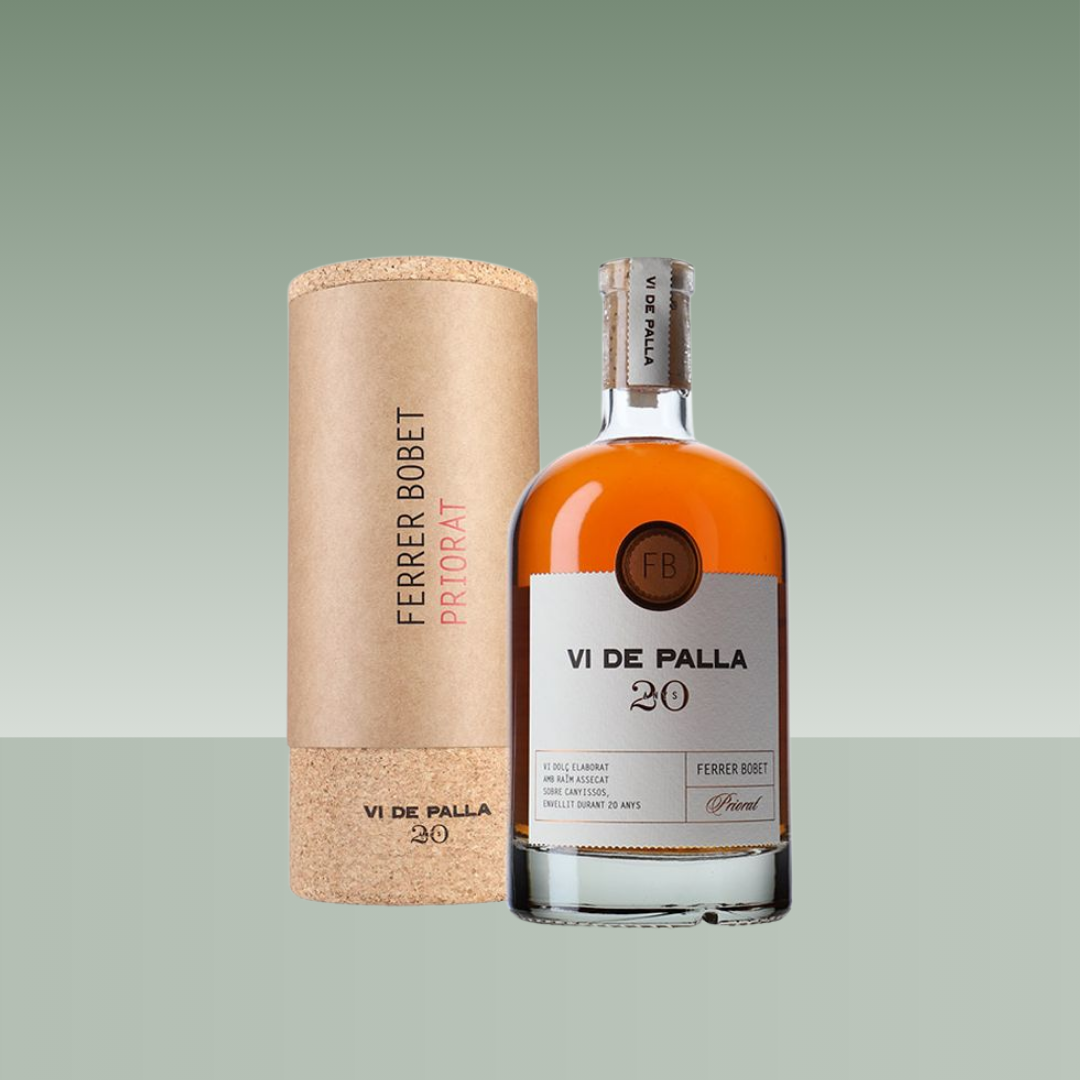 Botella de vino rancio Ferrer Bobet Vi de Palla 20 Priorat, con color ámbar intenso, etiqueta clara y tapón natural, presentada junto a su estuche cilíndrico de cartón y corcho sobre fondo neutro.