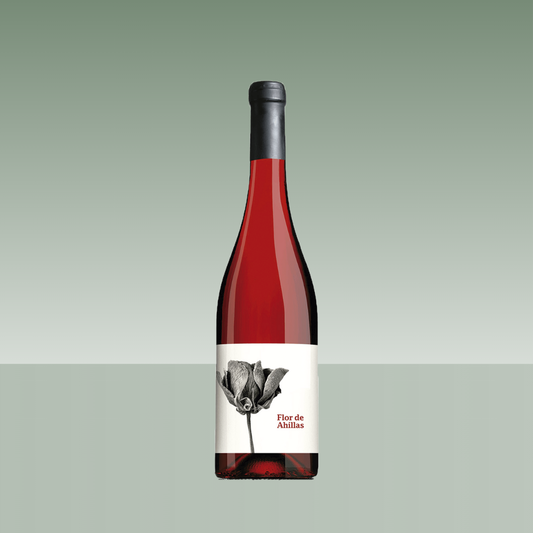 Botella de vino rosado Flor de Ahillas, con vidrio transparente de tono rosado intenso, cápsula negra y etiqueta blanca con ilustración floral en blanco y negro y el nombre del vino en rojo.