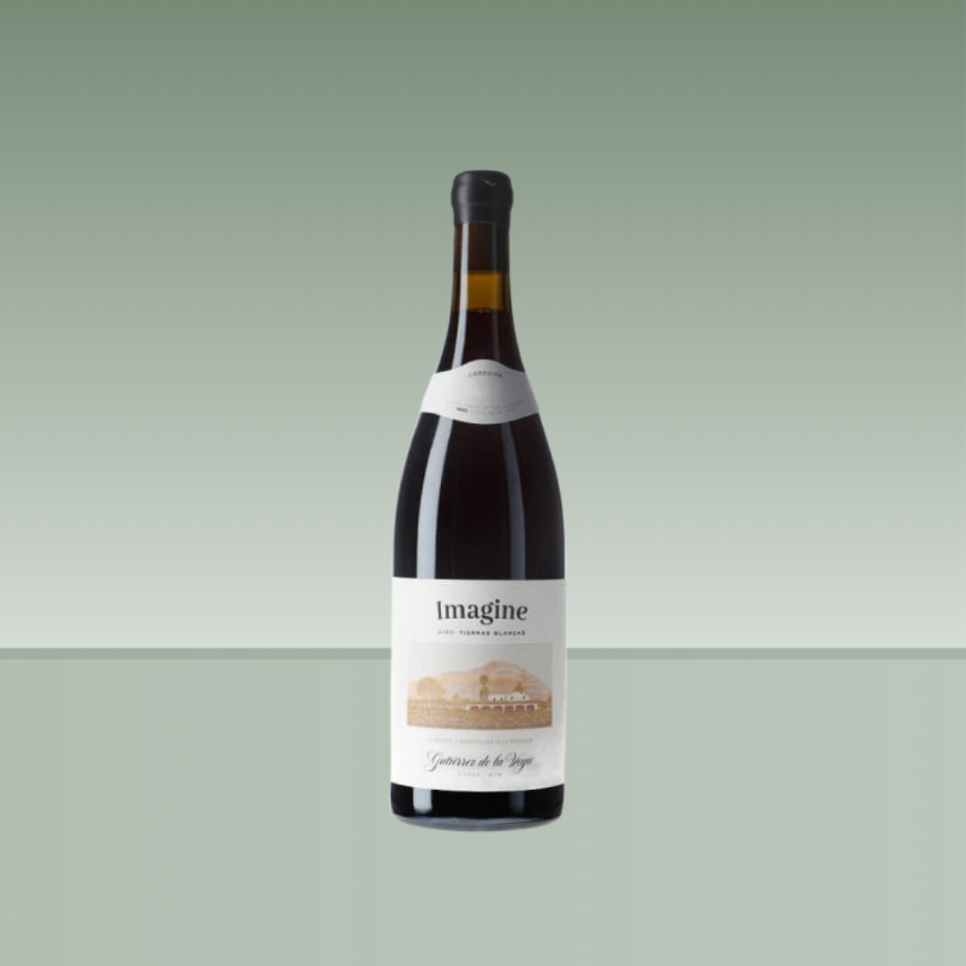 Botella de vino tinto Imagine, con vidrio oscuro, cápsula negra y etiqueta blanca con ilustración de paisaje en tonos beige.
