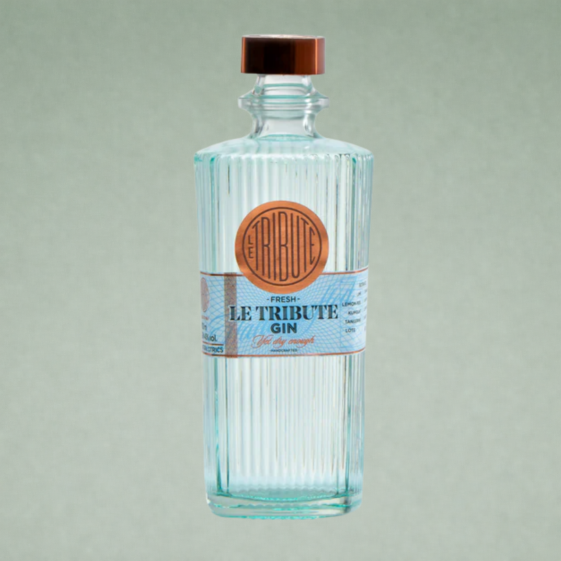 Botella de Le Tribute Gin Fresh, ginebra premium con diseño elegante en cristal estriado y etiqueta azul clara sobre fondo neutro.