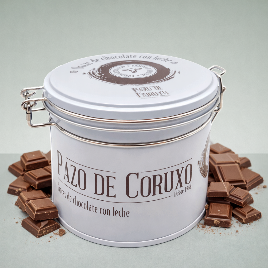Lata Pazo de Coruxo galletas de chocolate con leche con trozos de chocolate alrededor.
