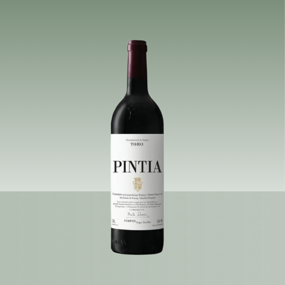 Botella de vino tinto Pintia con cápsula burdeos y etiqueta blanca de diseño clásico. Muestra la D.O. Toro y el logotipo de la bodega Tempos Vega Sicilia.